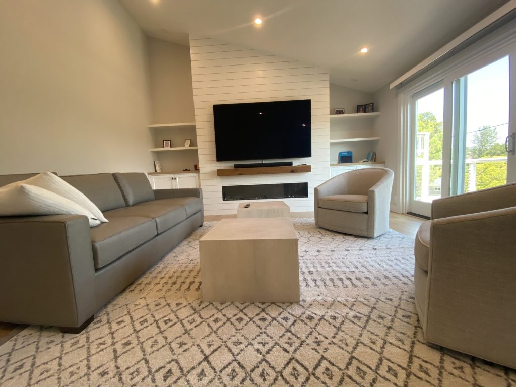 Remodeled living room with shiplap fireplace and built-in media storage