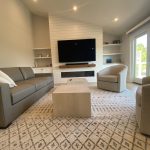 Remodeled living room with shiplap fireplace and built-in media storage